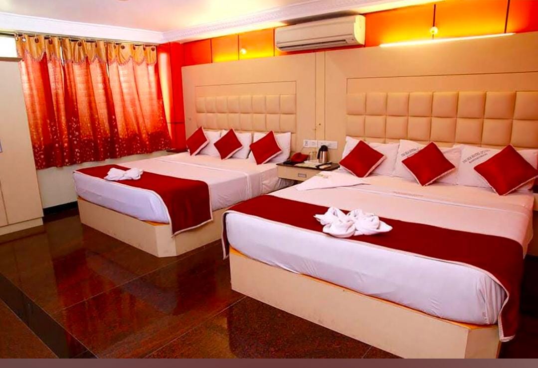 Family room at Gujarat Bhavan Rameswaram with two large beds and red furnishings