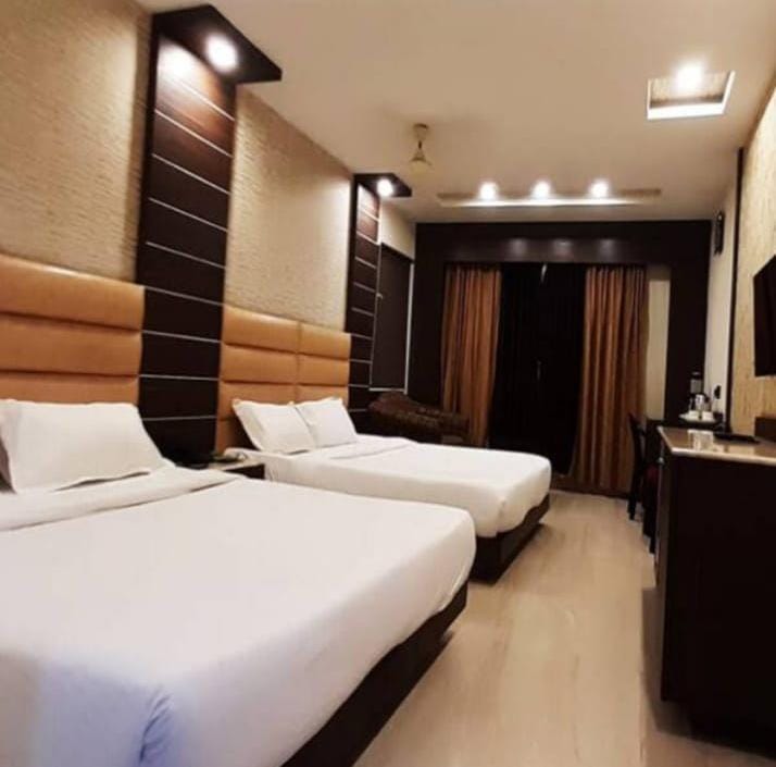 Guest room at Gujarat Bhavan Rameswaram with two beds and wooden headboards