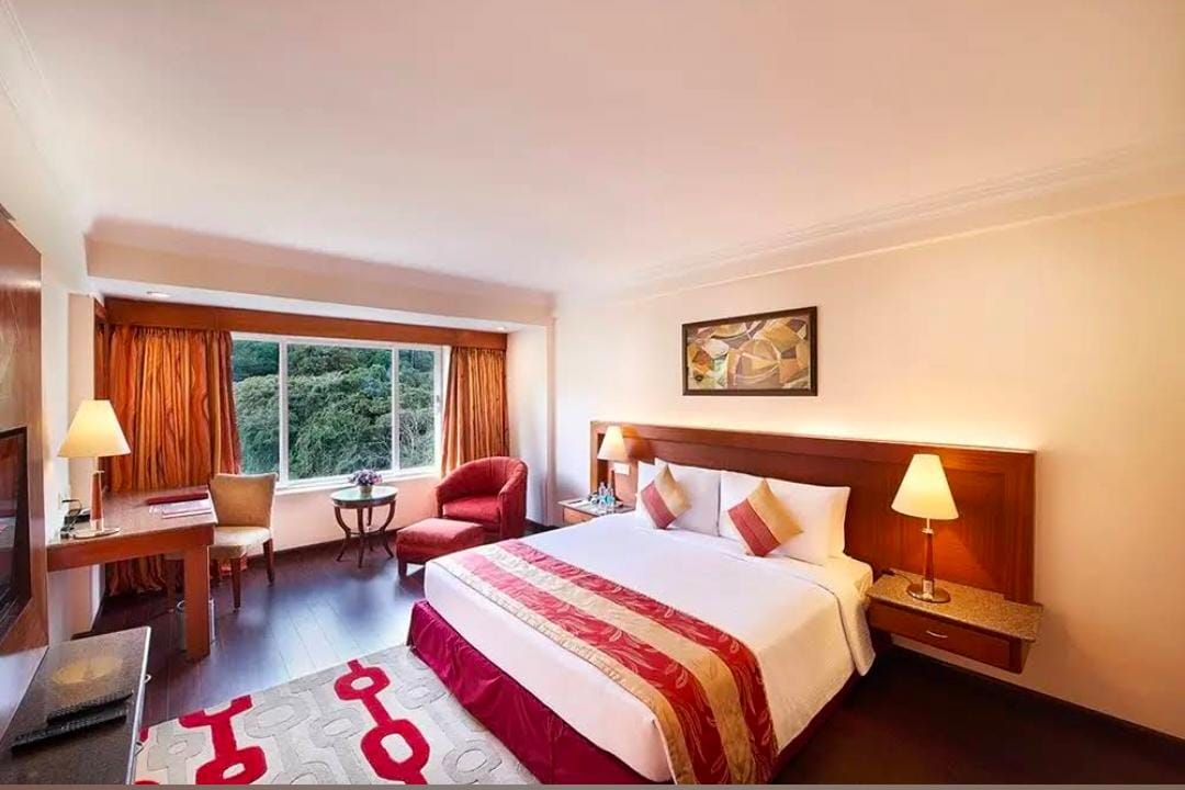 Guest room at Gujarat Bhavan Rameswaram with a double bed, desk and armchair